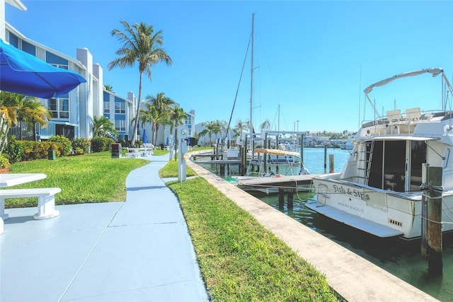 view of dock with a water view and a lawn