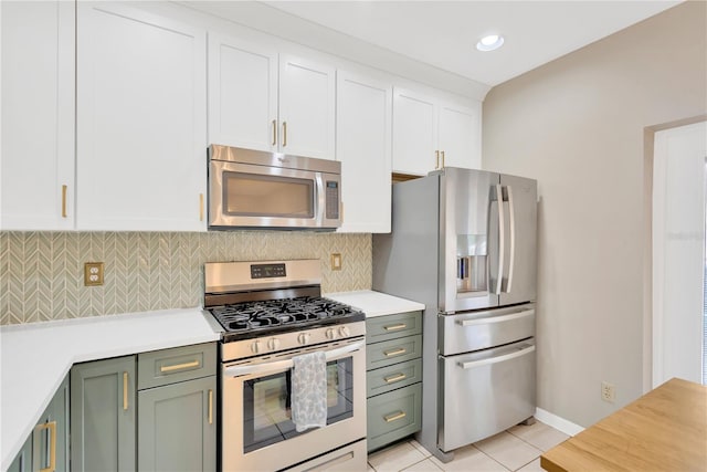 kitchen featuring white cabinets, light tile patterned floors, backsplash, and appliances with stainless steel finishes