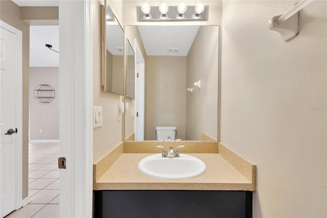 bathroom featuring tile patterned flooring, vanity, and toilet