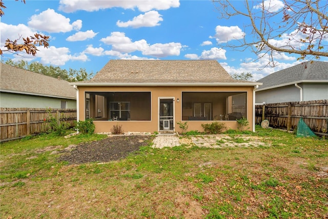 back of house with a sunroom and a yard