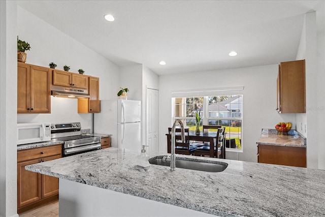 kitchen featuring vaulted ceiling, light stone countertops, sink, and white appliances