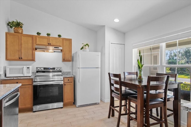 kitchen featuring light stone countertops and stainless steel appliances