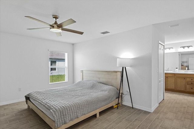 bedroom with ensuite bathroom, ceiling fan, and sink