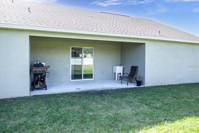 back of property with a patio area and a yard