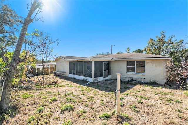 rear view of property featuring a sunroom