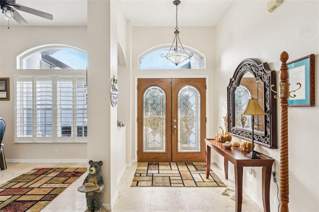 foyer featuring ceiling fan, french doors, a towering ceiling, and plenty of natural light