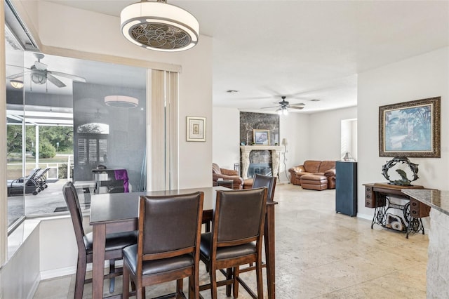 dining space featuring a fireplace and ceiling fan