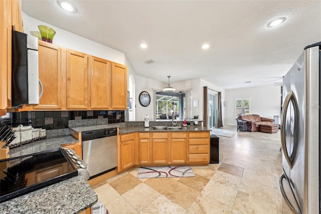 kitchen with sink, tasteful backsplash, decorative light fixtures, kitchen peninsula, and stainless steel appliances