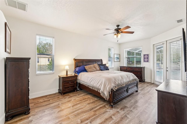 bedroom with access to outside, ceiling fan, light hardwood / wood-style floors, and a textured ceiling