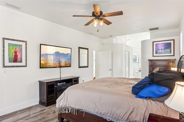 bedroom with light wood-type flooring, connected bathroom, and ceiling fan