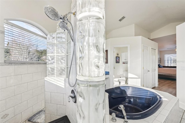 bathroom featuring a shower, hardwood / wood-style floors, and vaulted ceiling