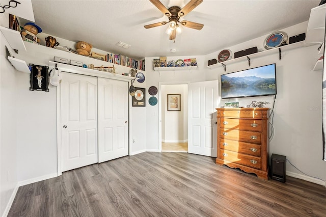 unfurnished bedroom featuring ceiling fan, a closet, and hardwood / wood-style floors