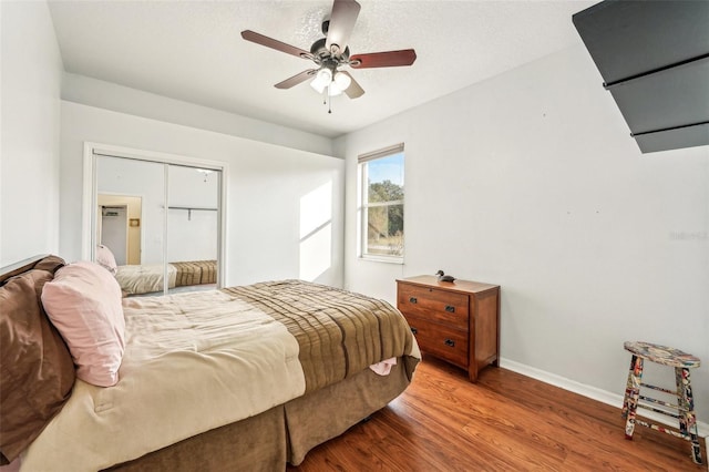 bedroom featuring wood-type flooring, a closet, and ceiling fan