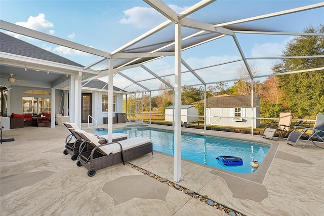 view of swimming pool with glass enclosure, outdoor lounge area, a patio, and a shed