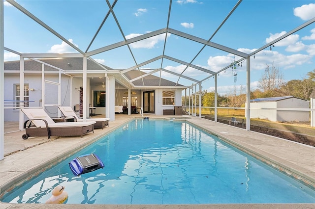 view of pool featuring glass enclosure and a patio area