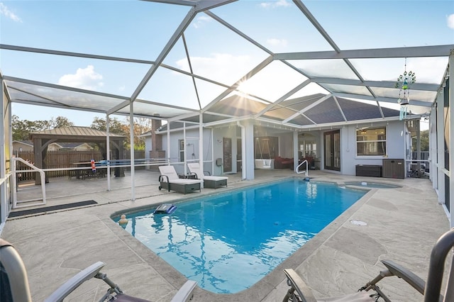 view of swimming pool with a gazebo, a patio area, an in ground hot tub, and glass enclosure