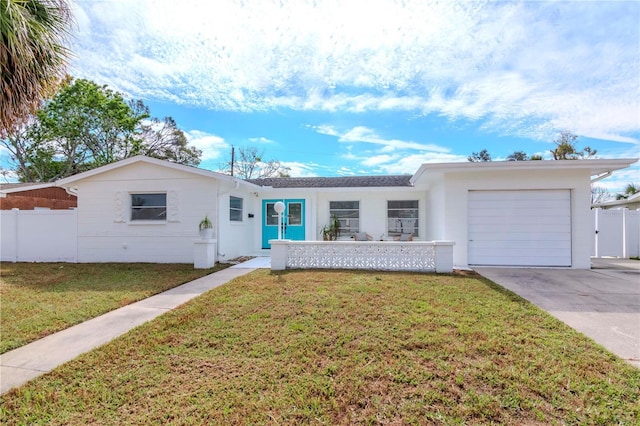 ranch-style house with a garage and a front lawn