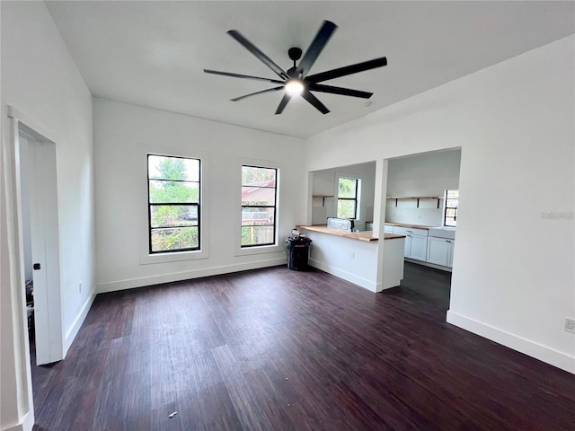 unfurnished living room featuring dark hardwood / wood-style floors and ceiling fan