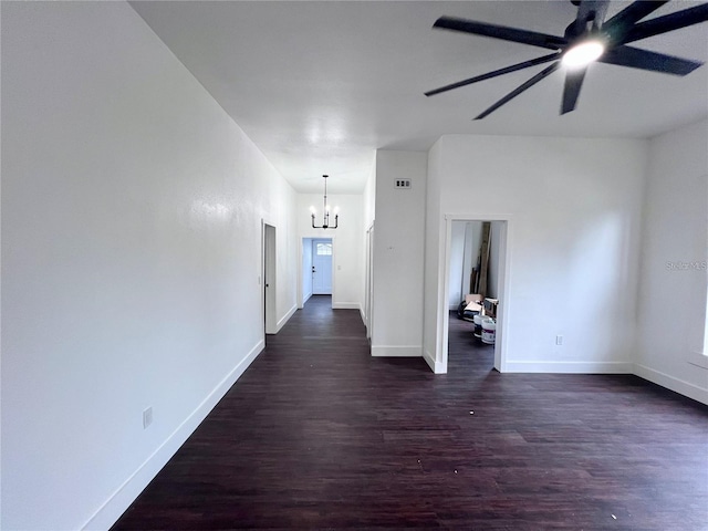 corridor with dark hardwood / wood-style floors and an inviting chandelier