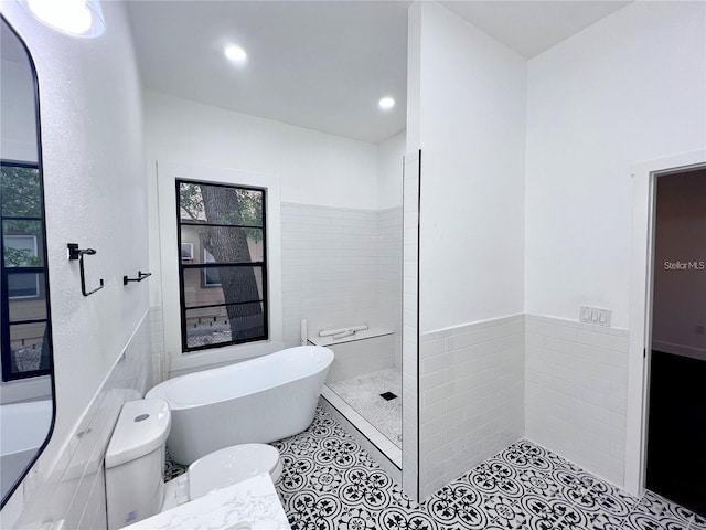 bathroom featuring toilet, tile patterned flooring, tile walls, and shower with separate bathtub