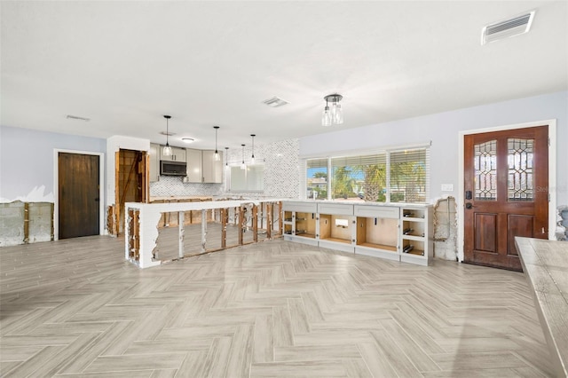 kitchen with decorative backsplash, decorative light fixtures, and light parquet floors