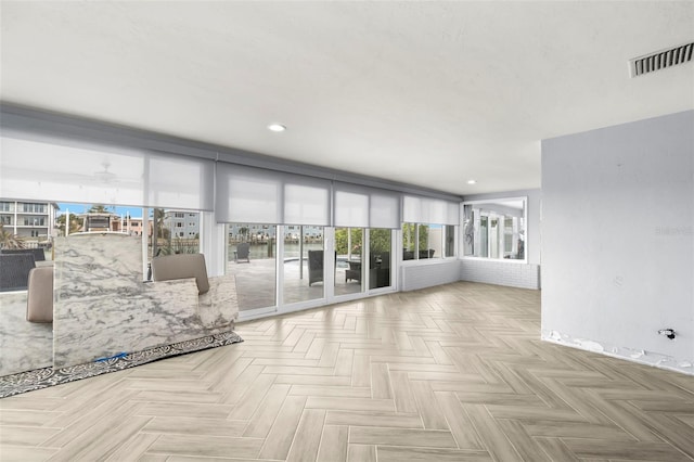 unfurnished living room with ceiling fan and light parquet flooring