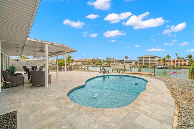 view of swimming pool with ceiling fan, a water view, and a patio