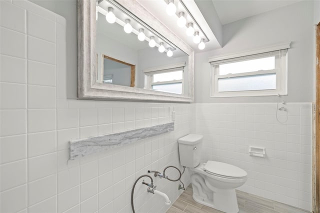 bathroom featuring toilet and tile walls