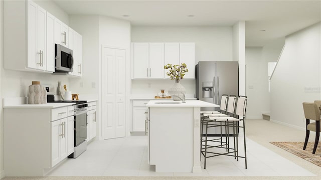 kitchen with white cabinets, appliances with stainless steel finishes, and an island with sink