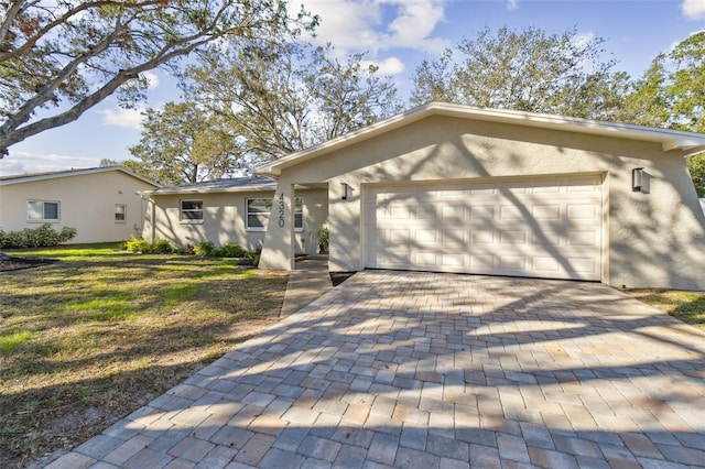 ranch-style house with a garage and a front yard