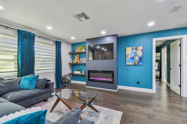 living room featuring a textured ceiling and dark wood-type flooring