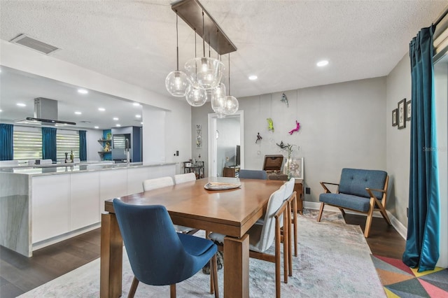 dining space featuring dark hardwood / wood-style flooring and a textured ceiling