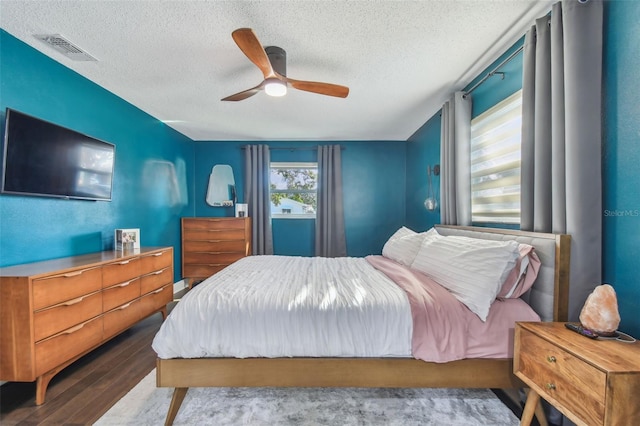 bedroom featuring ceiling fan, wood-type flooring, and a textured ceiling