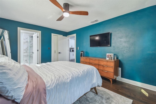 bedroom featuring ensuite bath, ceiling fan, dark hardwood / wood-style flooring, and a textured ceiling