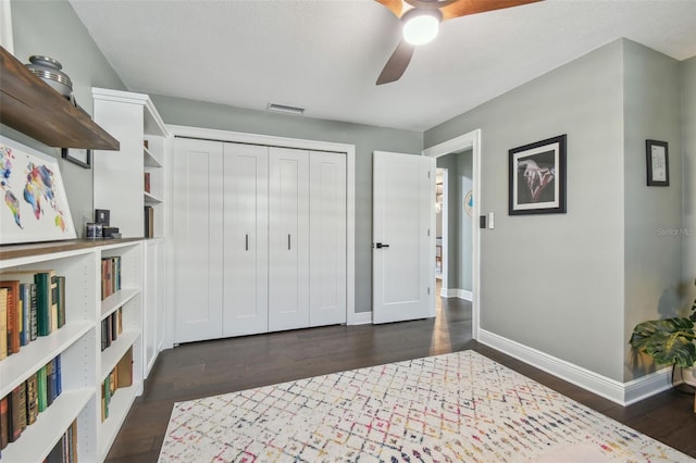 bedroom with dark hardwood / wood-style flooring, ceiling fan, a closet, and a textured ceiling