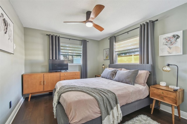 bedroom with multiple windows, ceiling fan, and dark wood-type flooring