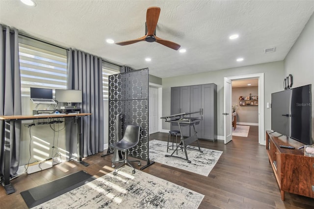 interior space featuring dark hardwood / wood-style flooring, a textured ceiling, and ceiling fan