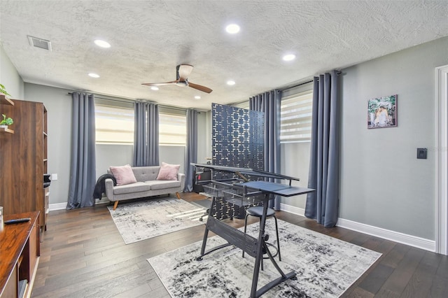 home office featuring ceiling fan, dark hardwood / wood-style floors, and a textured ceiling