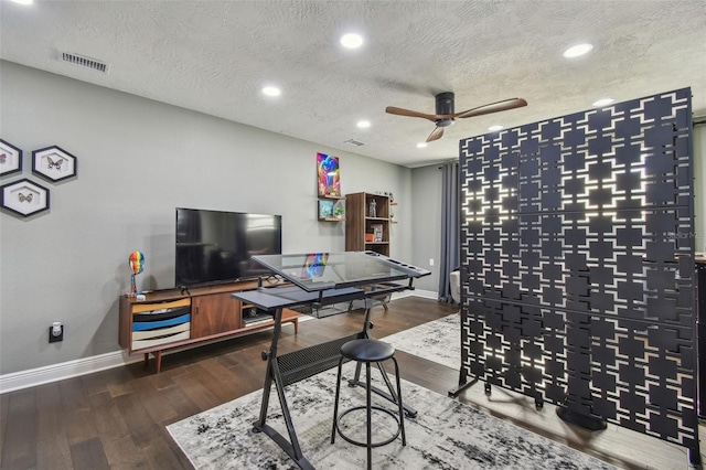 game room with ceiling fan, wood-type flooring, and a textured ceiling