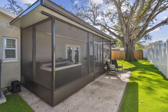 view of property exterior featuring a yard, a patio area, and a sunroom