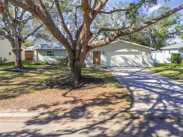 ranch-style home with a garage and a front lawn