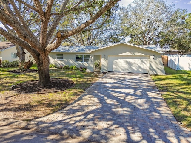 single story home featuring a front lawn and a garage