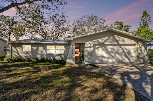 ranch-style home featuring a yard and a garage