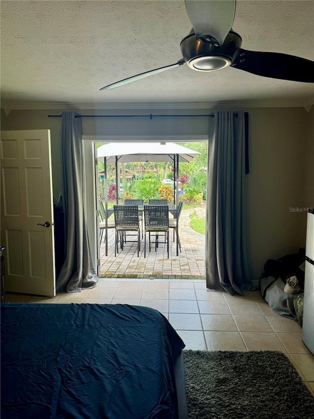 bedroom with access to exterior, light tile patterned floors, a textured ceiling, and ceiling fan