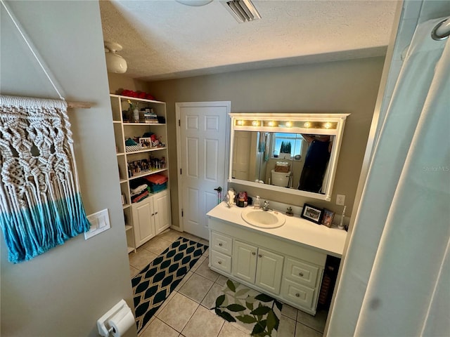 bathroom featuring tile patterned floors, vanity, and a textured ceiling