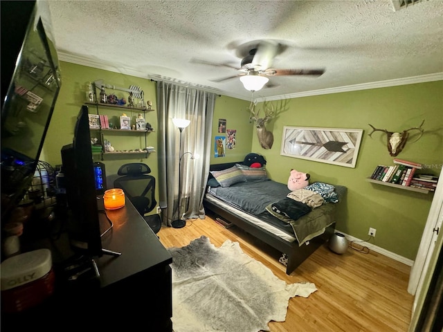 bedroom featuring a textured ceiling, light hardwood / wood-style floors, ceiling fan, and crown molding