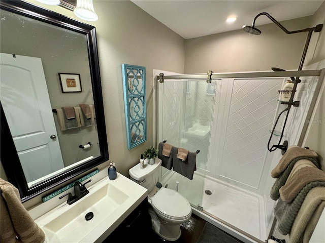 bathroom featuring vanity, toilet, and a shower with shower door