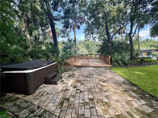 view of patio / terrace featuring a hot tub and a deck