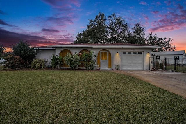 ranch-style house featuring a lawn and a garage