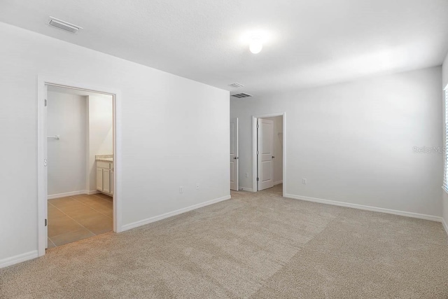 unfurnished room featuring light carpet